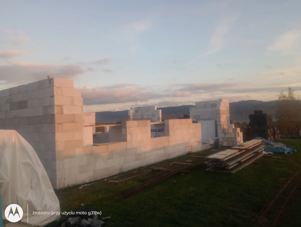 Białe betonowe bloczki układane na płycie fundamentowej, ściany domu, Stan surowy otwarty